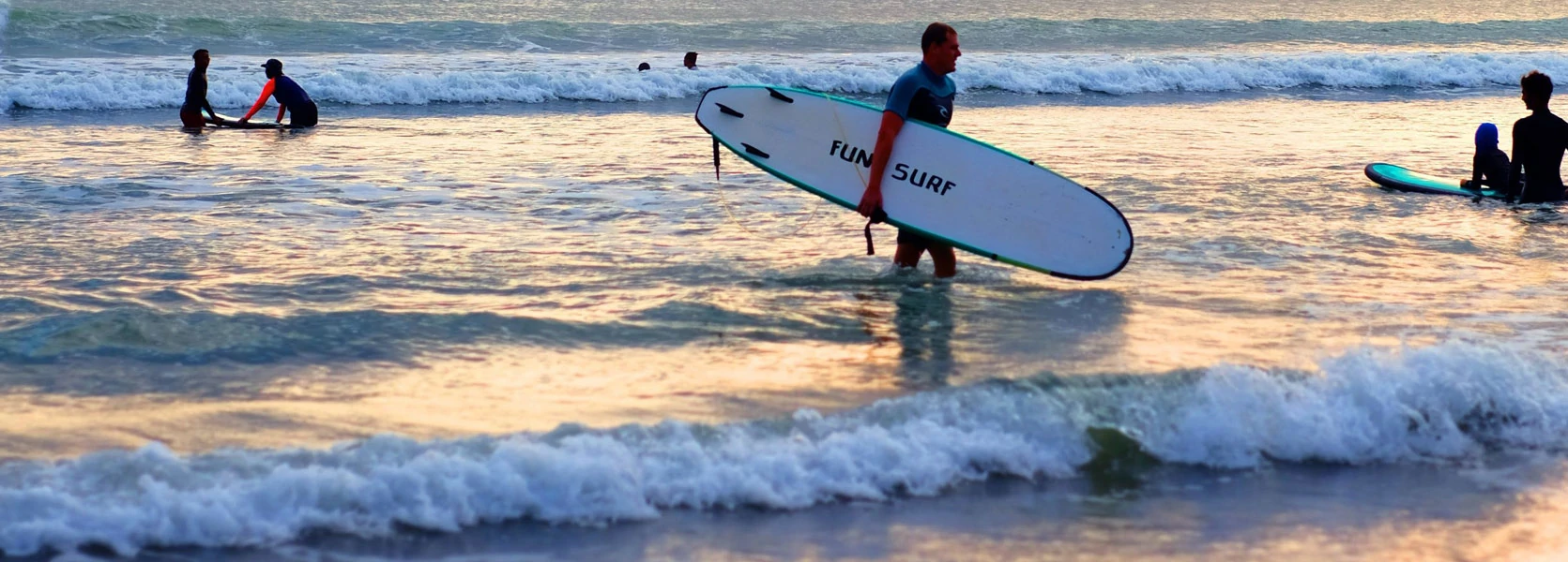 Les activités et loisirs autour de Lacanau. Lacanau, Au bord de l'océan petites vagues, des surfeurs se croisent dans l'eau. A l'avant un surfeur sort de l'eau.