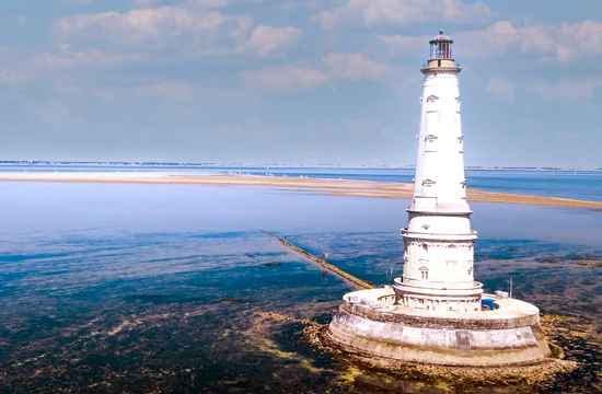 Les activités et loisirs autour de Lacanau. Le phare de Cordouan au milieu de l'océan au loin un banc de sable apparait à marée basse