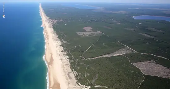 appart hôtel pasino n°7, vue aérienne de la bande côtière. A gauche l'océan, au centre la plage de sable blond et à droite la forêt domaniale autour de Lacanau. Au loin on voit deux étangs.
