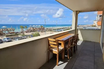 Appart hôtel Pasino n°1 grande terrasse vue l'océan. Au loin la plage nord. Sur la terrasse une table en Tecks et ses 4 chaises