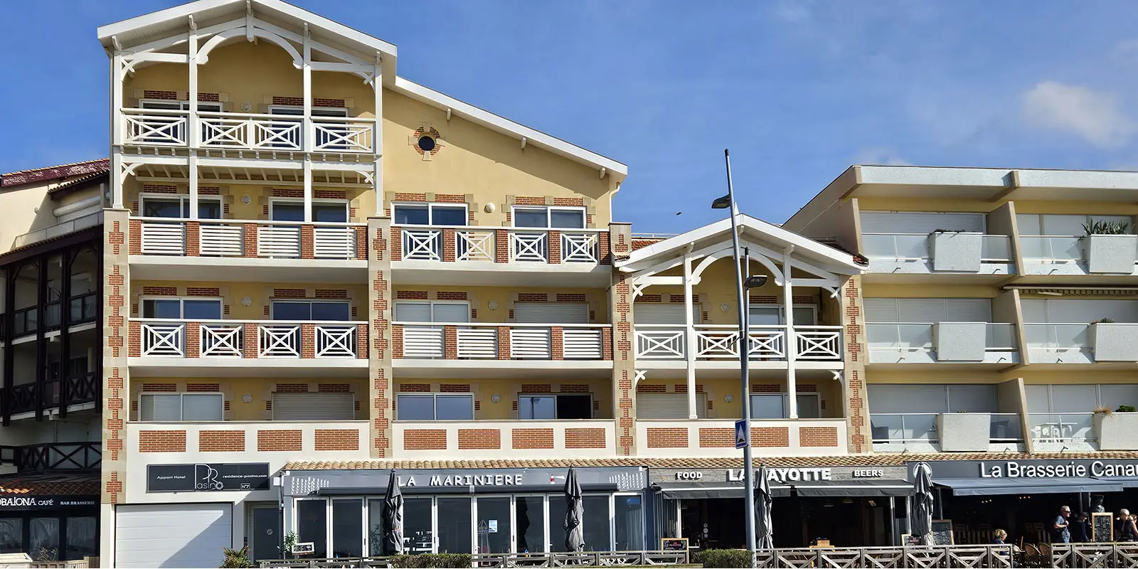 La résidence Pasino: bâtiment de 3 étages surplombant un ensemble de restaurants. Façade typique de la région mélange de bois et de briques