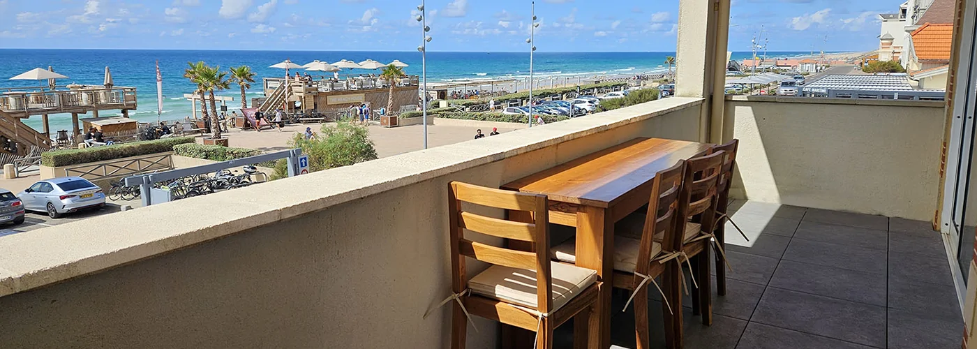 Appart hôtel Pasino n°1 grande terrasse vue l'océan. Au loin, la plage nord. Sur la terrasse une table en Tecks et ses 4 chaises