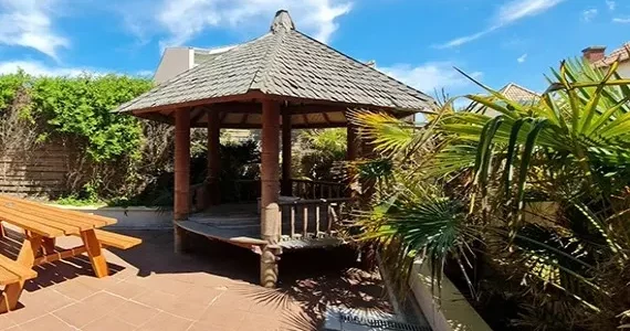 Appart-hotel-residence-pasino-appartement-n8-patio-570x450 appart hôtel pasino n°8, le patio de l'appartement, il est équipé d'une grande table et ses deux bancs, un gasebo et de la végétation donnent une touche exotique à l'espace