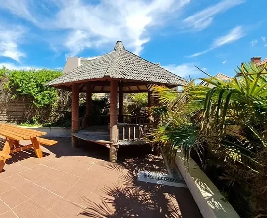 appart hôtel pasino n°8, le patio de l'appartement, il est équipé d'une grande table et ses deux bancs, un gasebo et de la végétation donnent une touche exotique à l'espace